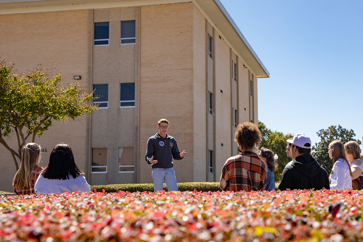 A Hawkseeker tour guide stands in front of a group of students on a Ƶ campus tour.